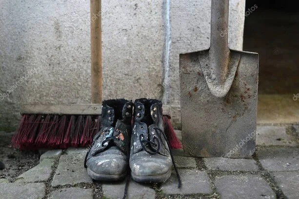 Hausmeister mit Werkzeugkoffer vor einem Mehrfamilienhaus